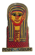 A colorful enamel pin shaped like an ancient Egyptian mummy mask, with a red and yellow body and black details, featuring the text 'PENN MUSEUM' at the bottom.