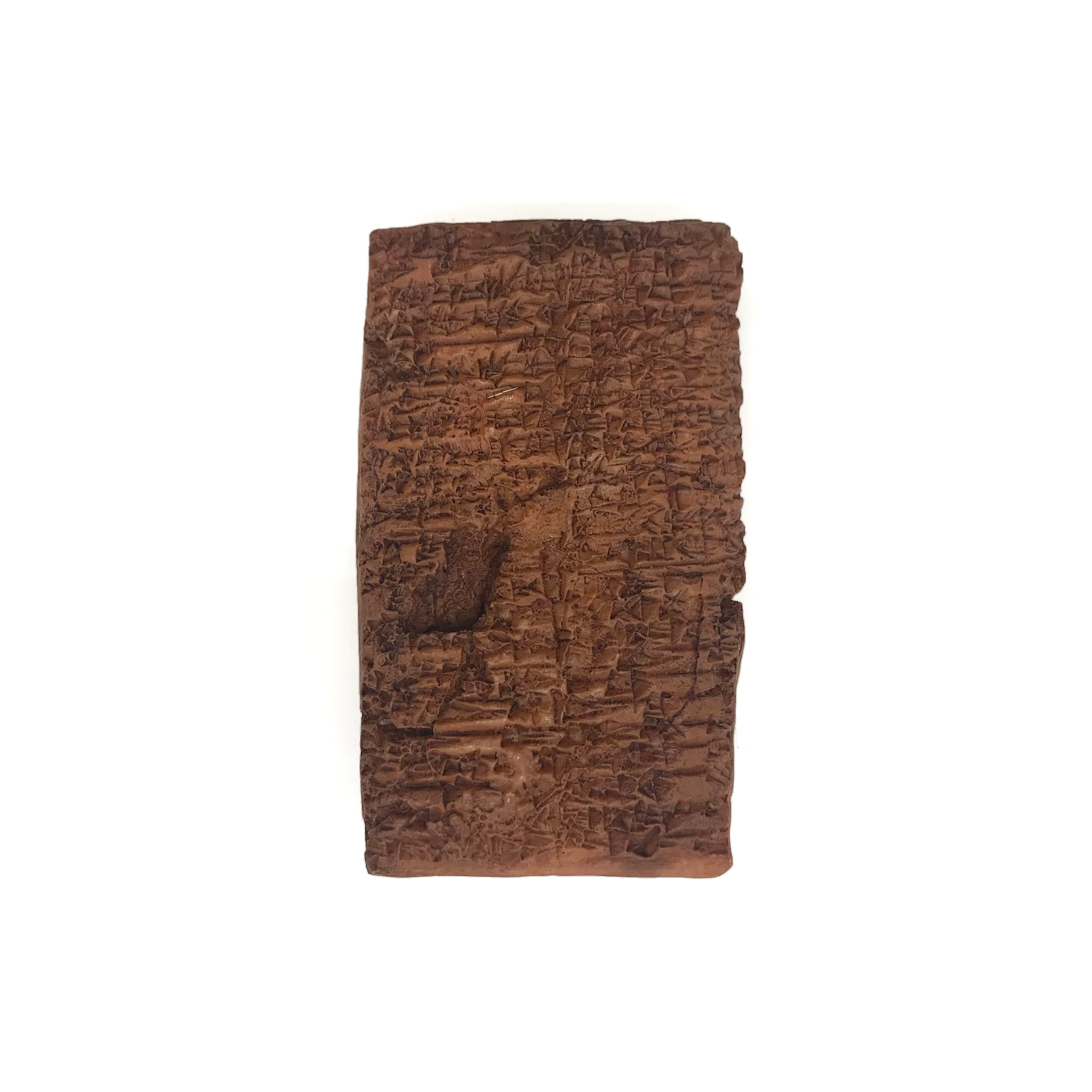 Reproduction of an ancient cuneiform tablet on a white background. Back.