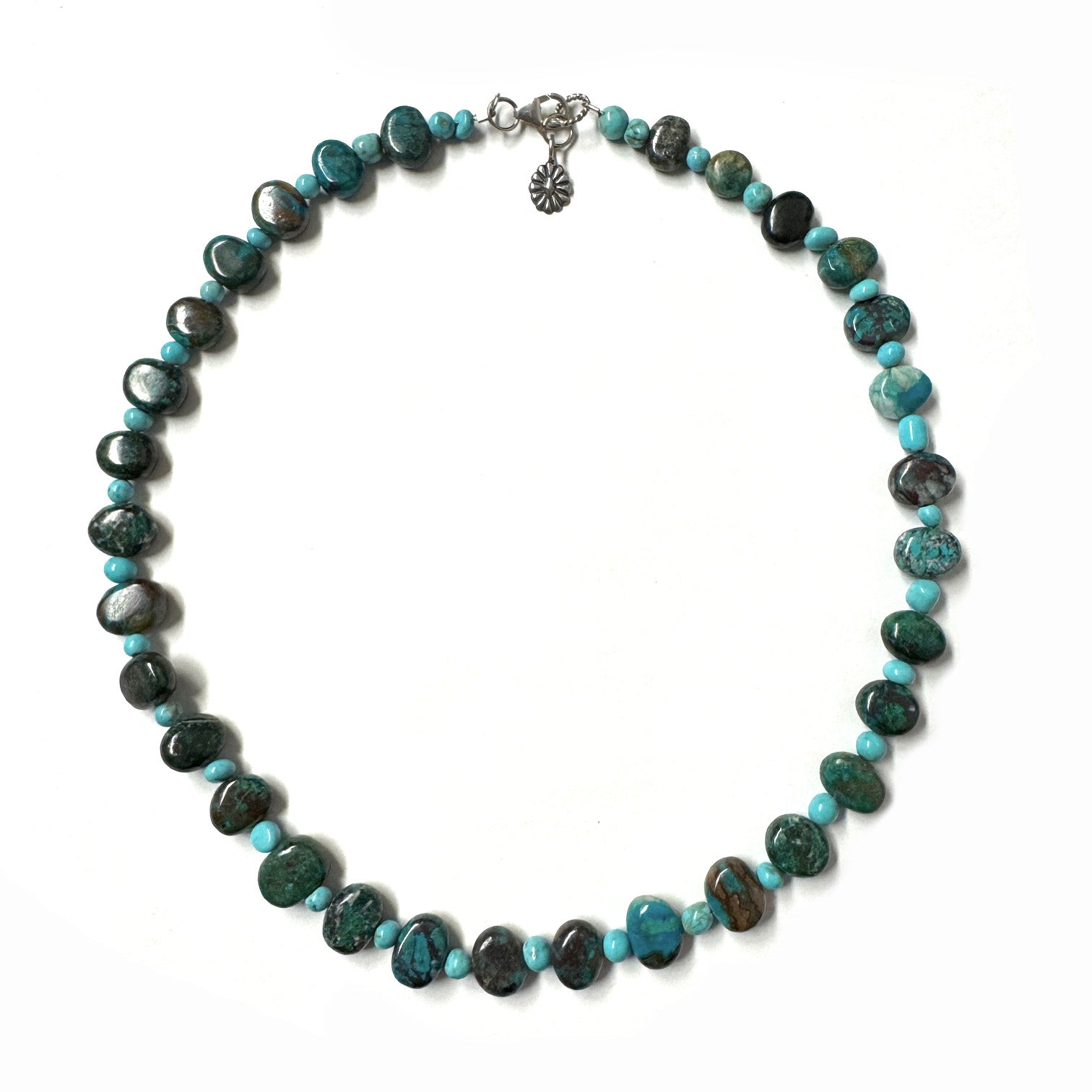 Necklace with turquoise beads in alternating sizes and varying shades on a white background