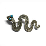 Silver snake-shaped brooch with turquoise stones for eyes on a white background