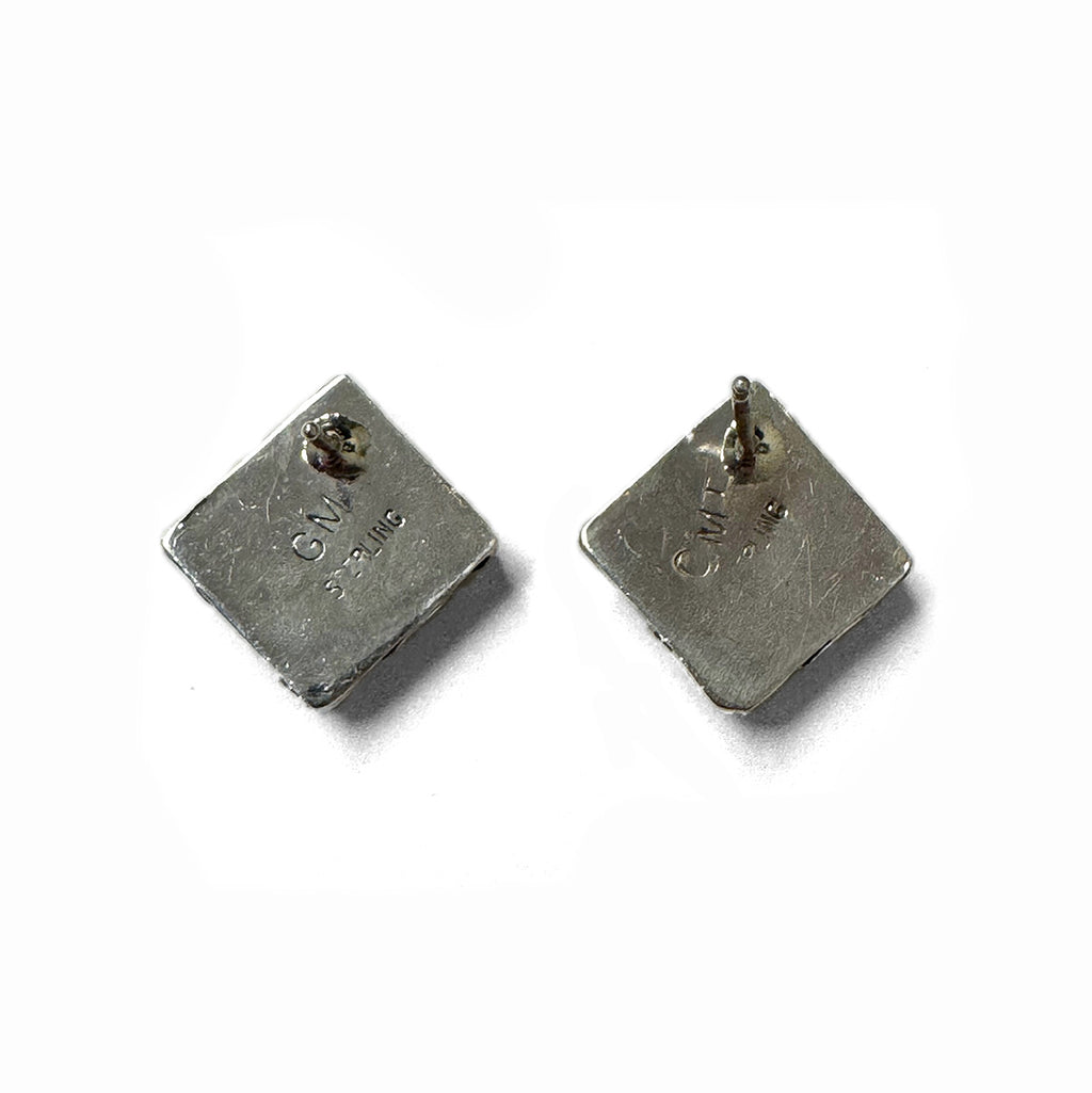 Back of a pair of silver square earrings on a white background
