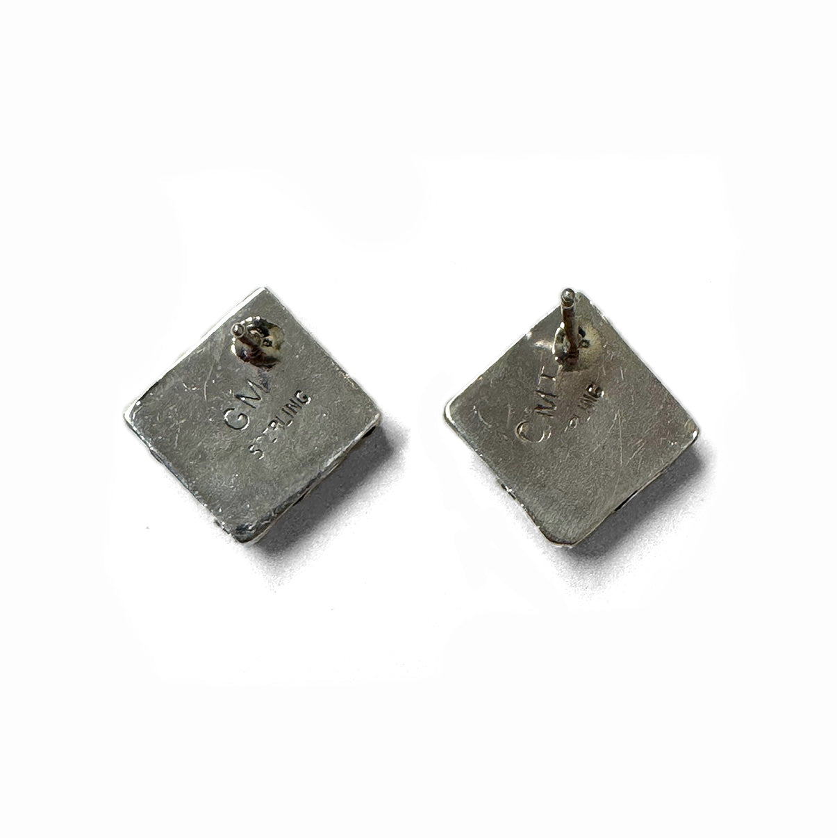 Back of a pair of silver square earrings on a white background