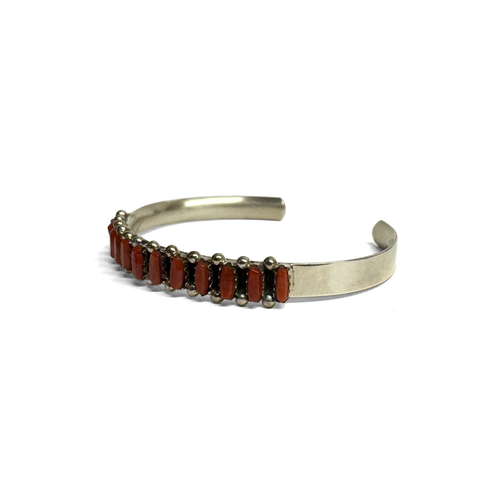 Sterling Silver bracelet with red Coral on a white background. Front view. Facing left.