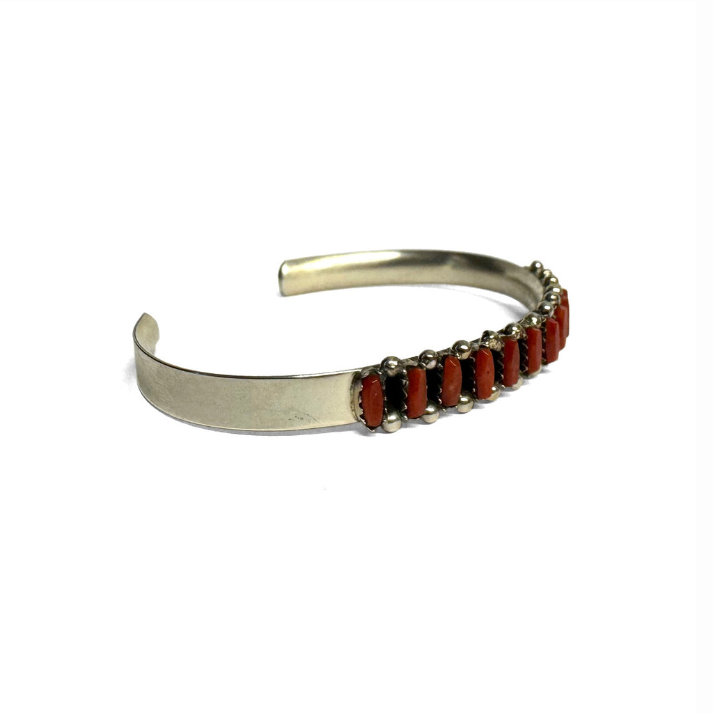 Sterling Silver bracelet with red Coral on a white background. Front view. Facing right.