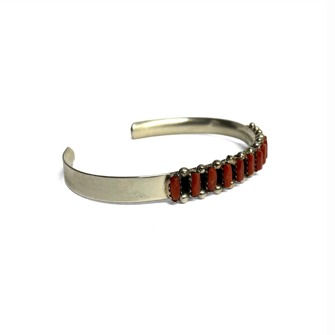 Sterling Silver bracelet with red Coral on a white background. Front view. Facing right.