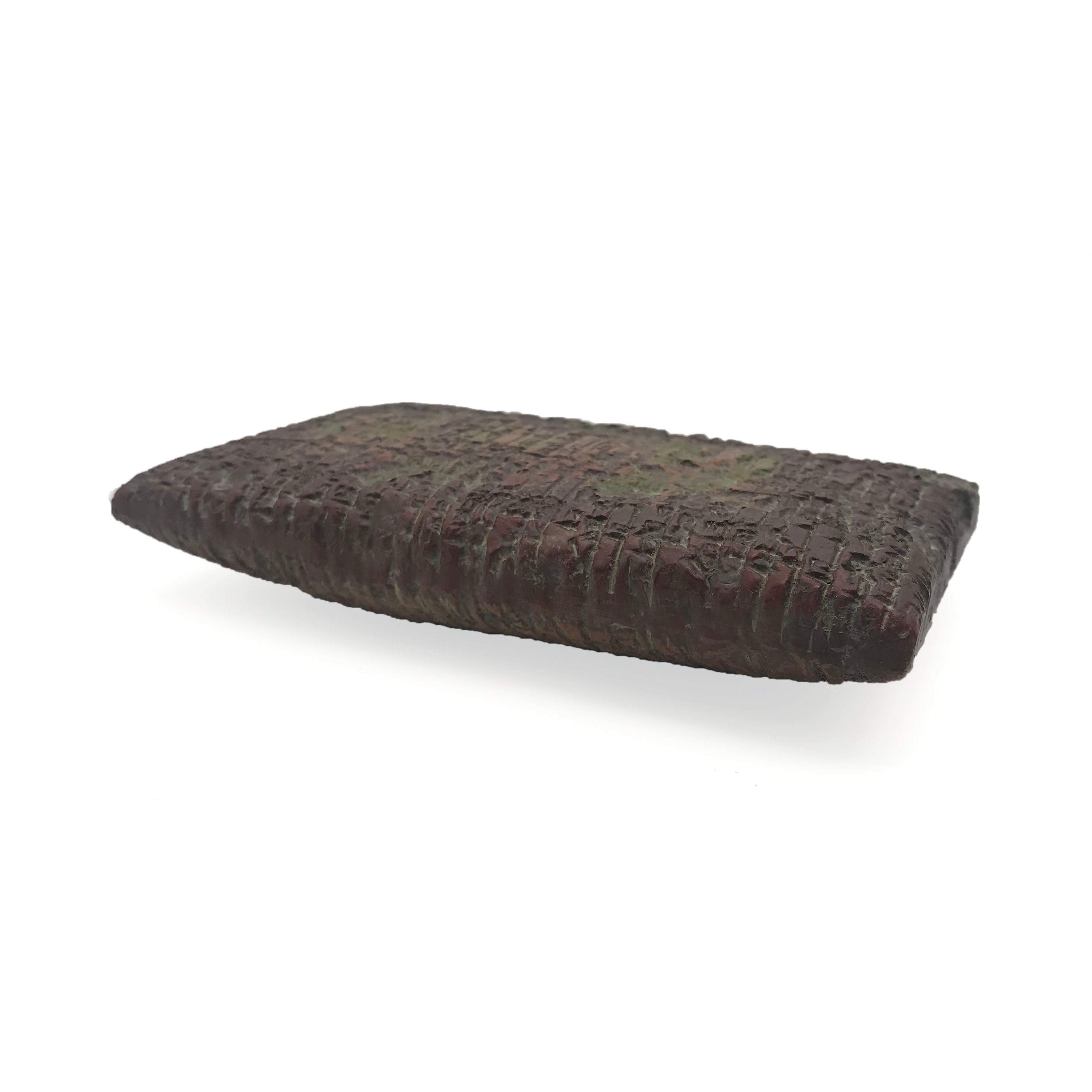 Reproduction of an ancient cuneiform tablet on a white background. Side.
