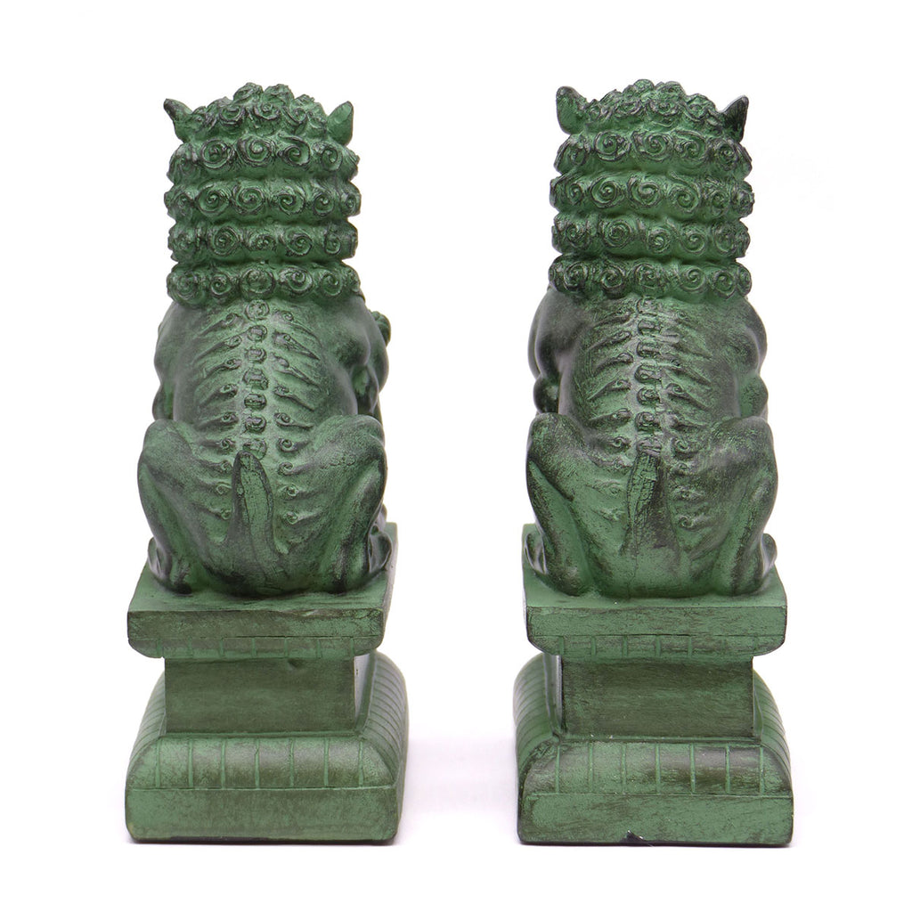 A pair of traditional Chinese Foo lions or Foo dogs, placed on bases, designed to resemble patinated bronze. Back view.
